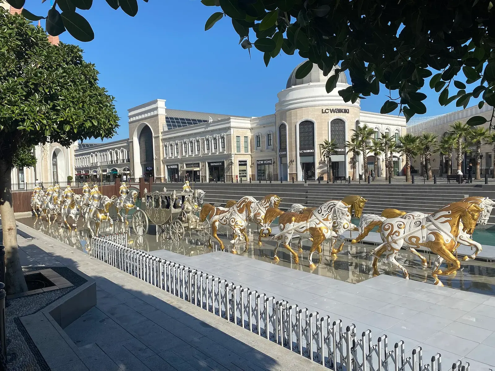 De winkelboulevard van The Land of Legends met een rij gouden paardenbeelden